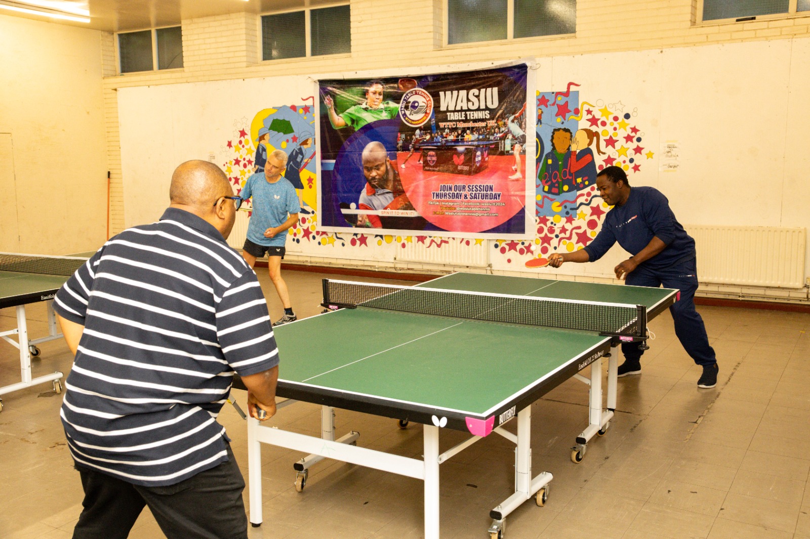 Players mid-rally at Wasiu Table Tennis, Manchester